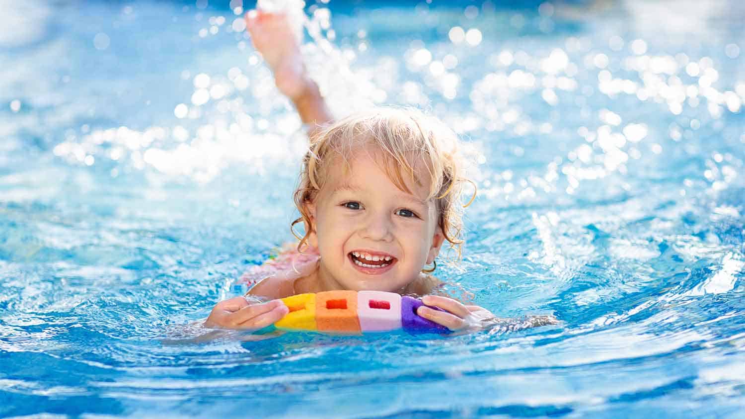 Happy young child swimming