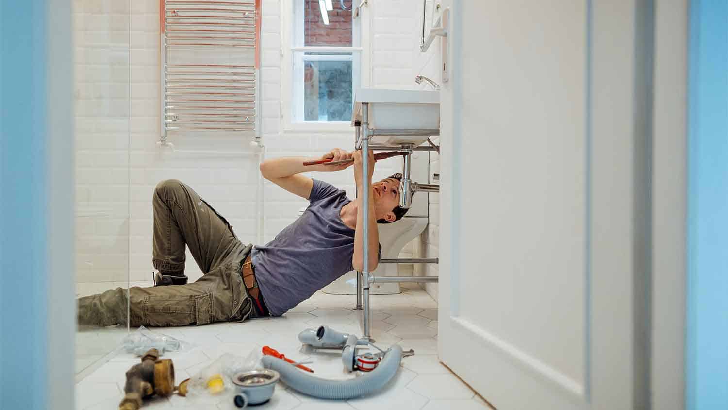 A plumber working under a sink