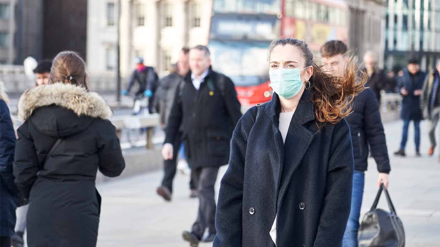 Woman walking and wearing a surgical mask