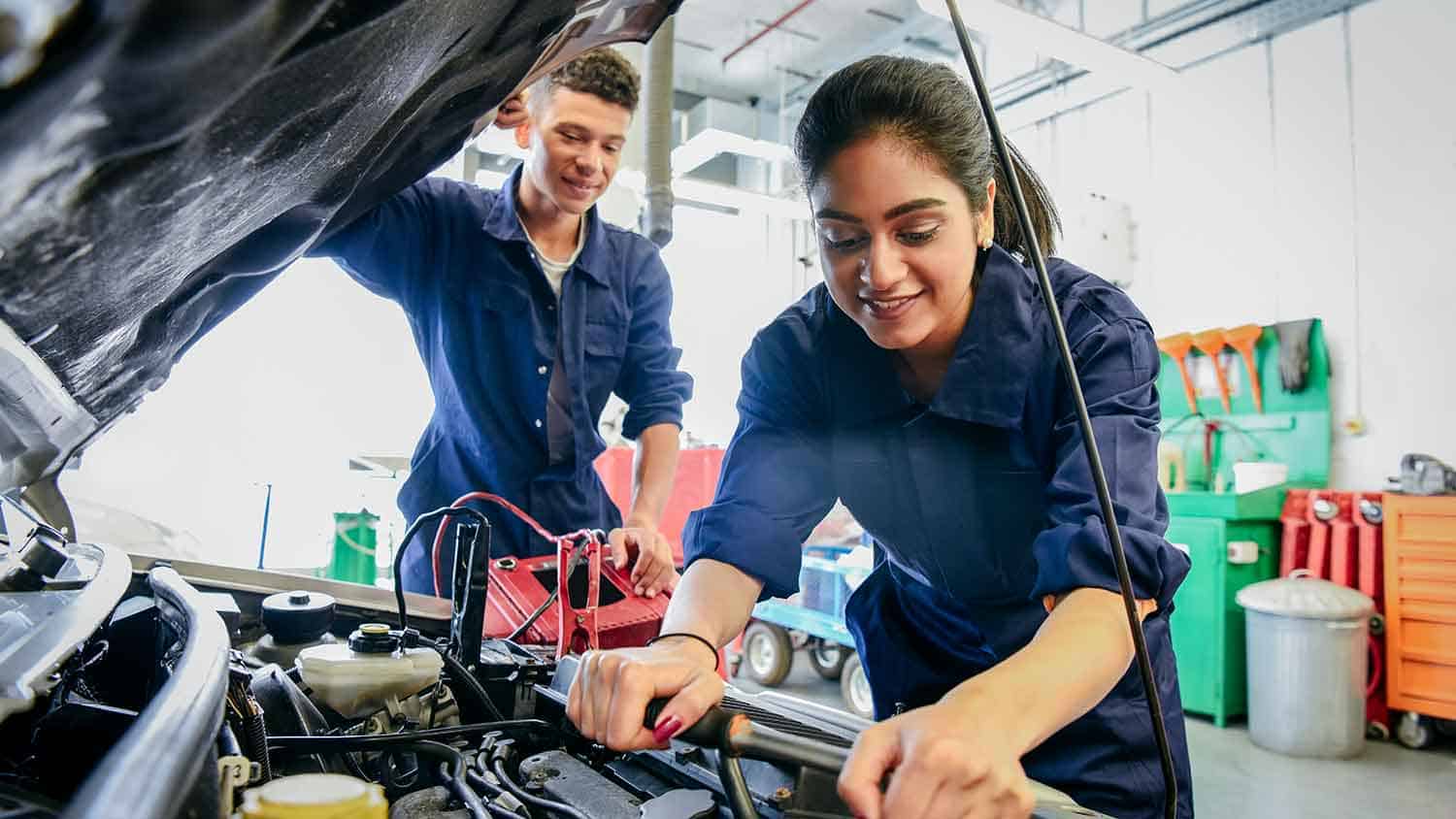 Two young car mechanics working