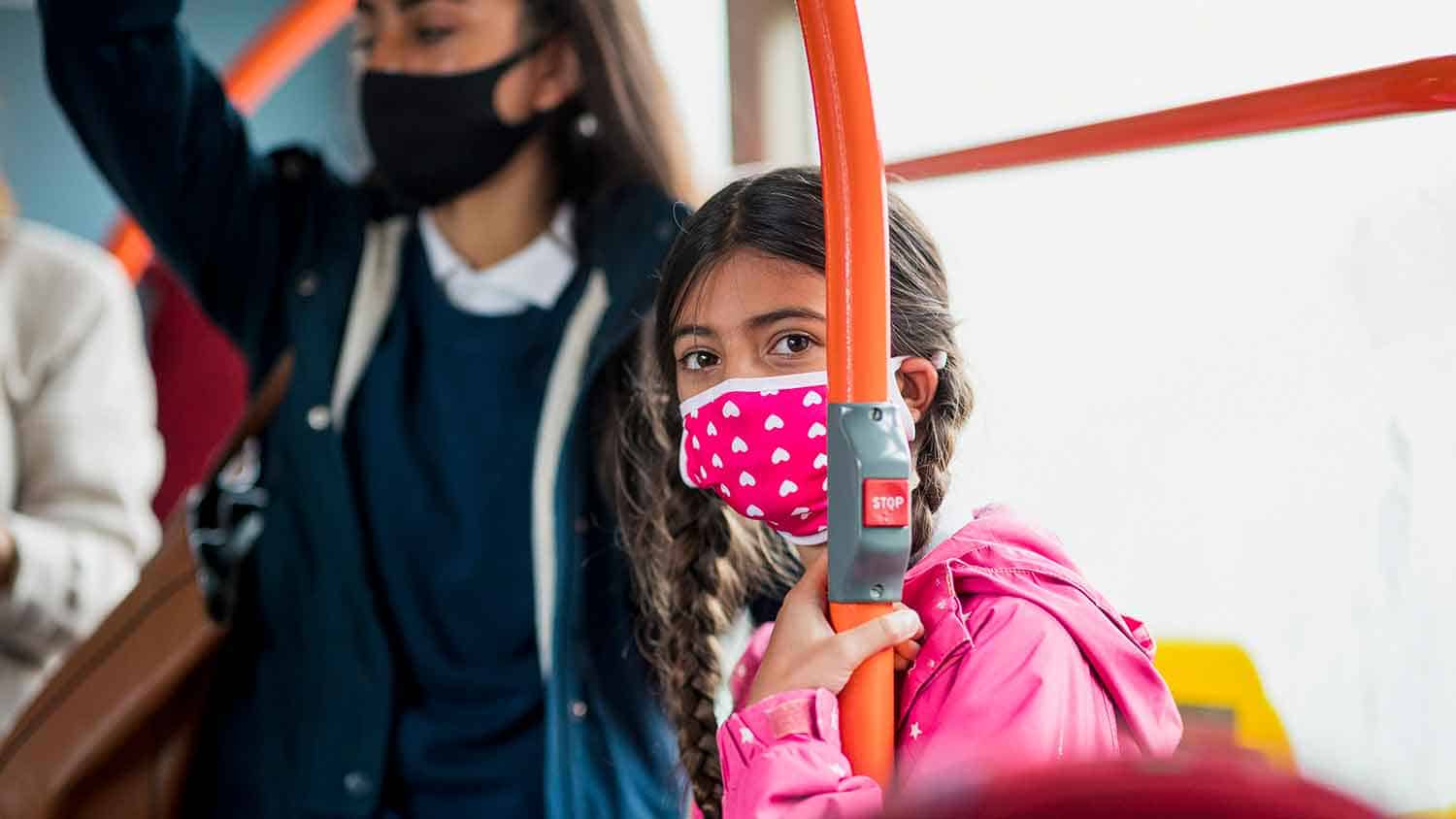 Child in a mask on a bus