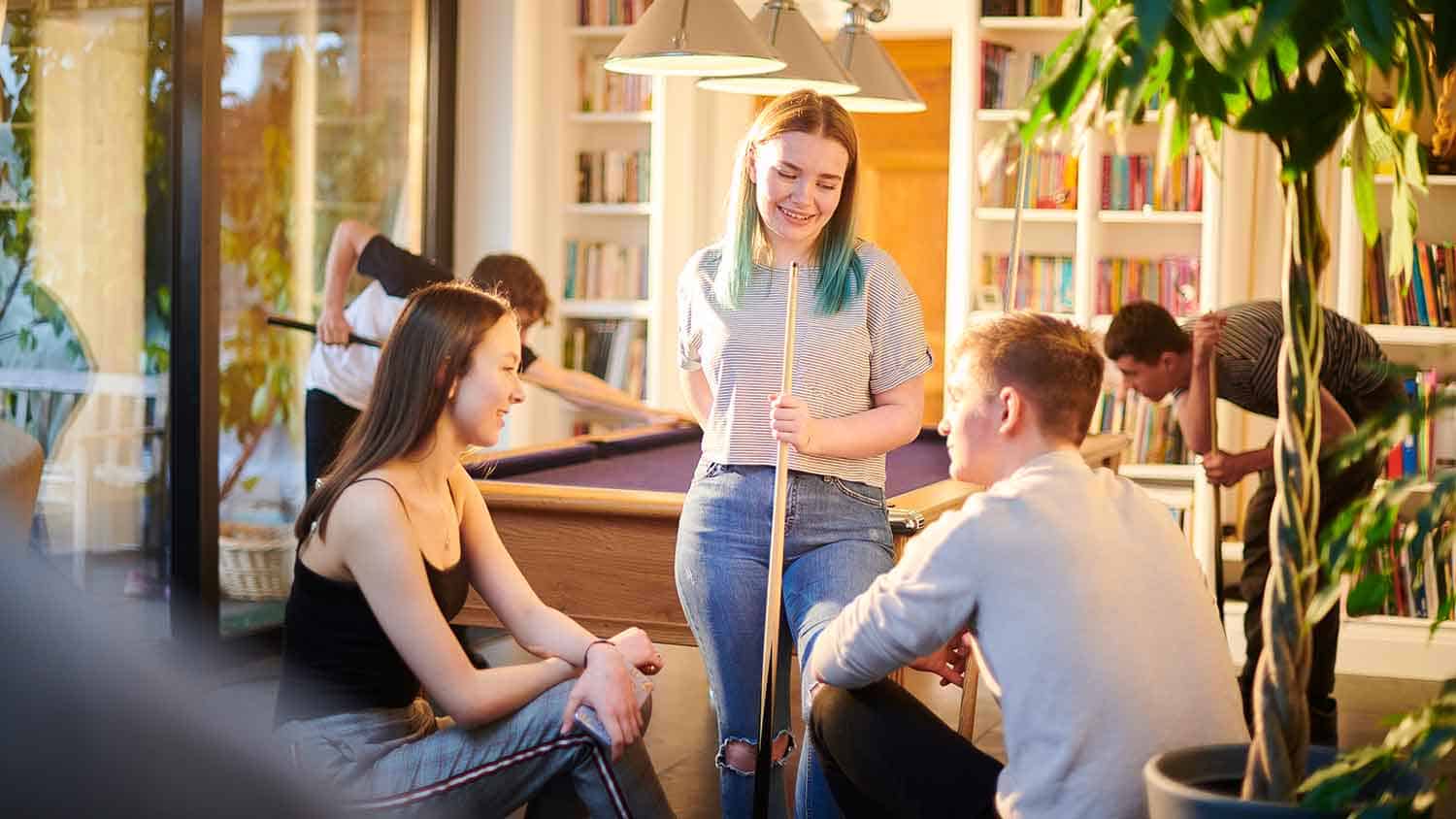 Young people playing pool at a youth club