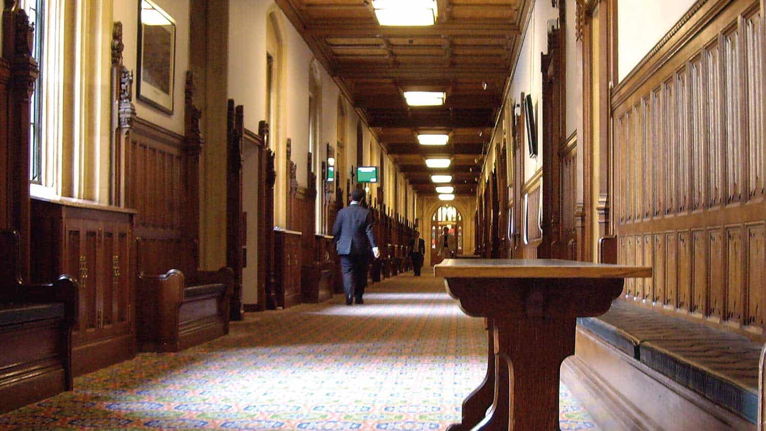 A view down one of parliament's long corridors, empty aside from a bench