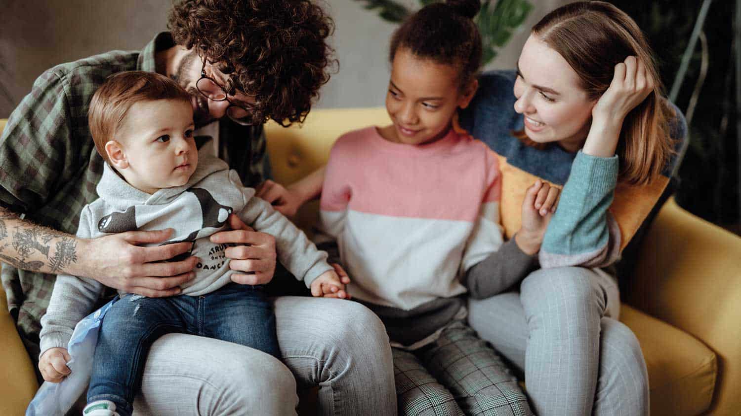 A family of four sit laughing together