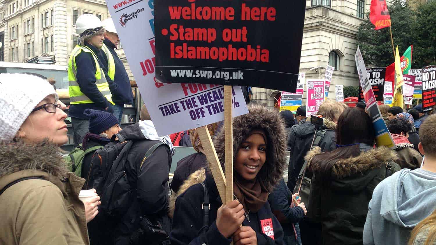 Young man holding a stamp out islamophobia sign at a protest