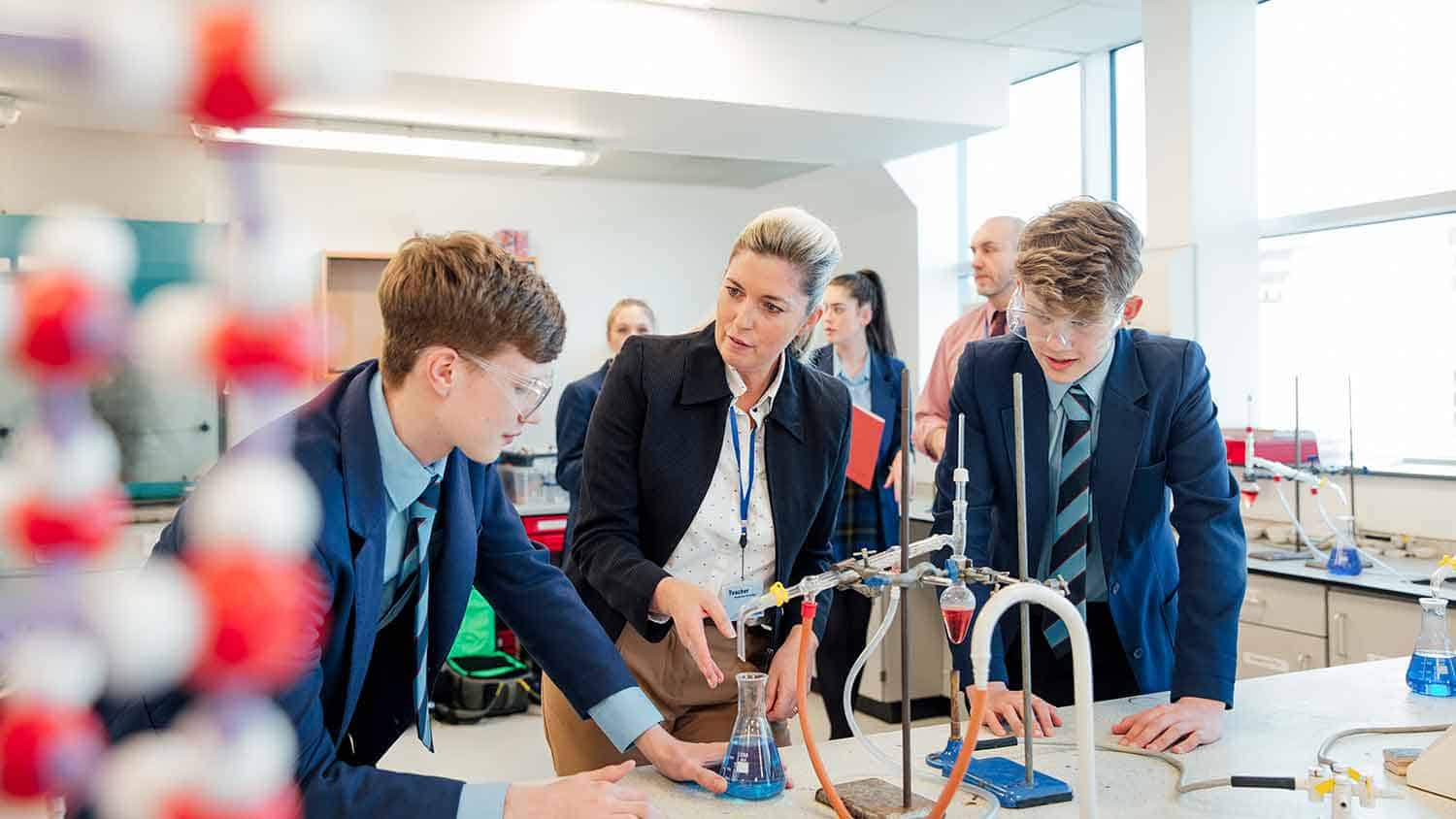 Two students in a science lesson being taught by a teacher