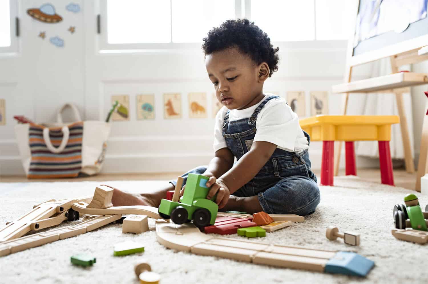 Child playing with a toy train set