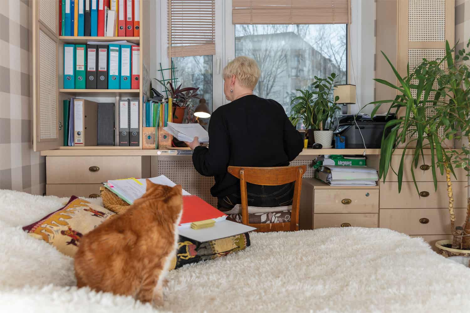 A lady studying at her computer in her bedroom