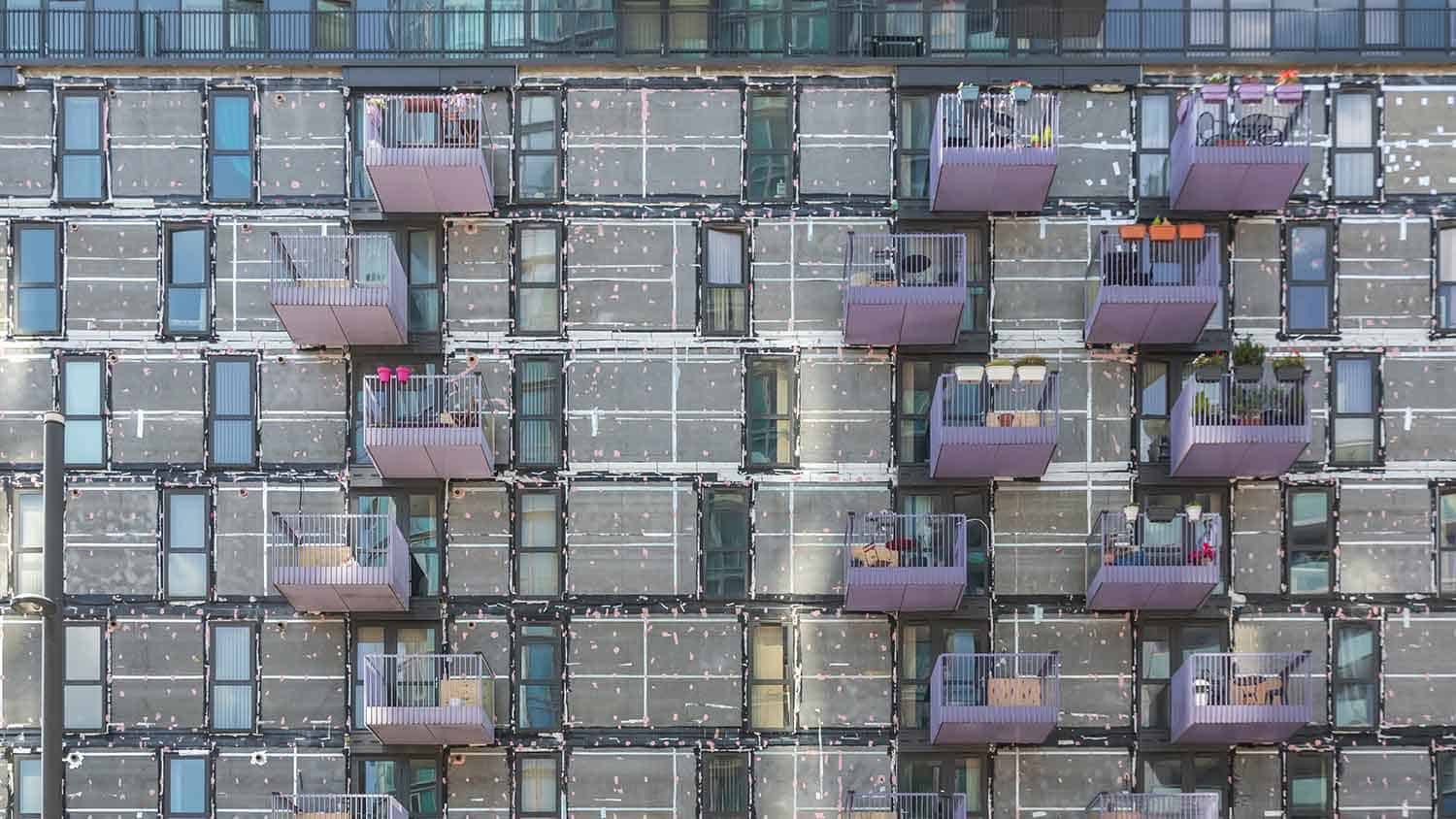 Cladding being removed from the side of a high rise apartment block