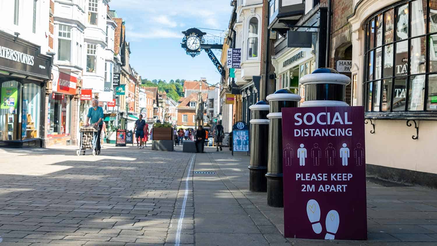 Social distancing sign in an old pedestrianised high street. Sign reads please keep 2m apart.