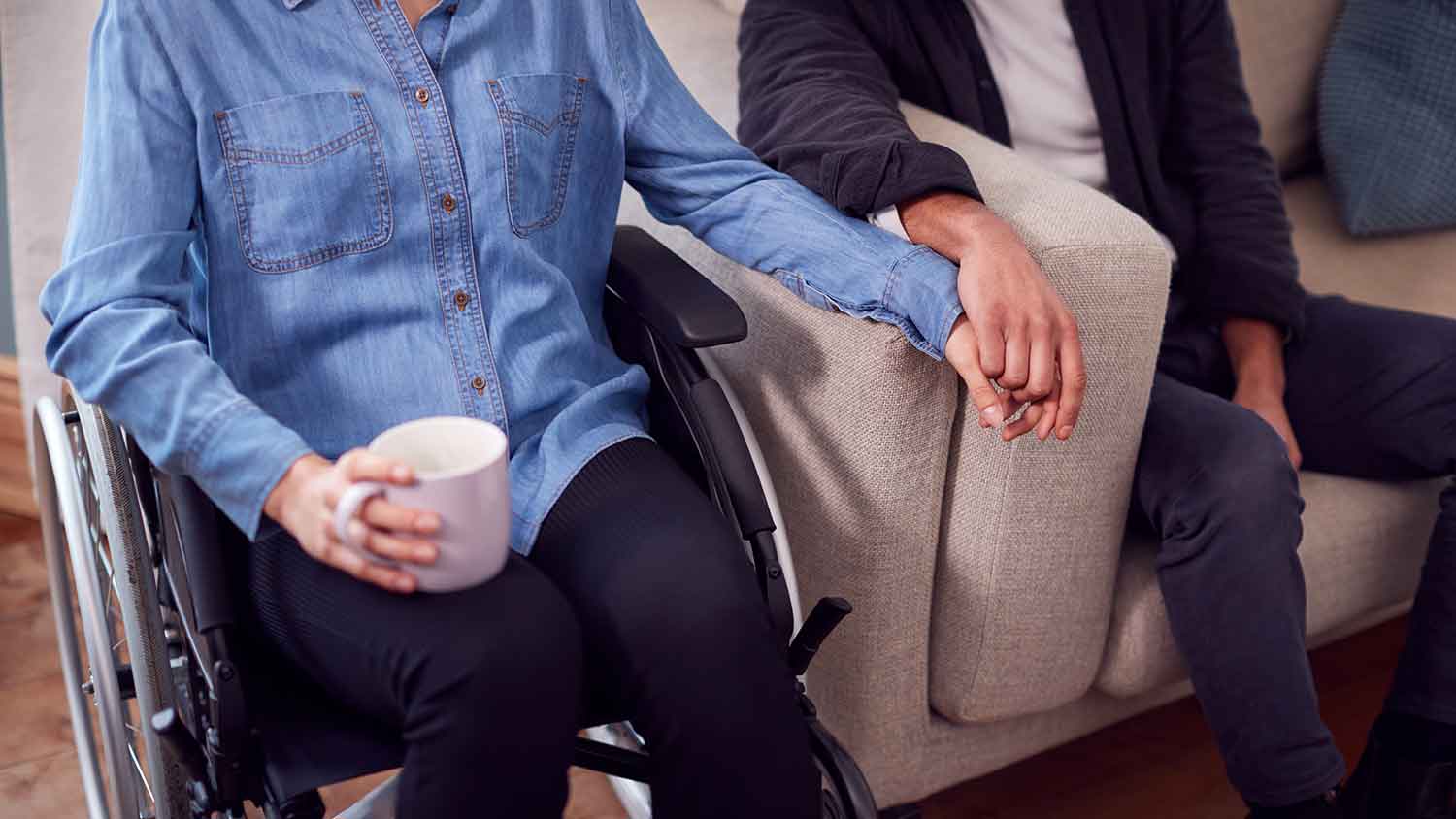 man and women holding hands sat on a chair