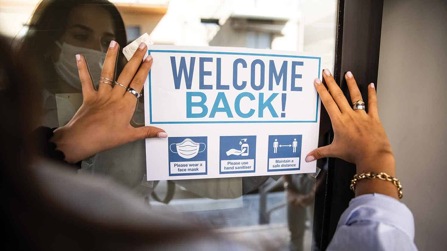 Welcome back sign with directions to wear a mask, use hand sanitiser and maintain distance