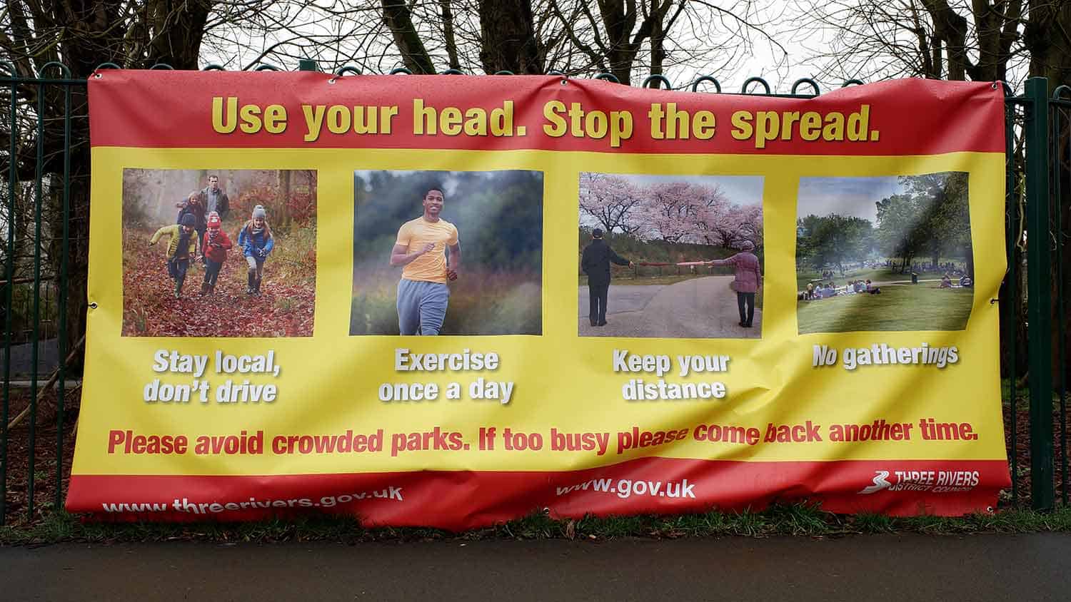 Sign saying 'use your head. Stop the spread' with examples of what you can and can't do including, 'Stay local don't drive', 'exercise once a day' 'keep your distance' and 'no gathering'.