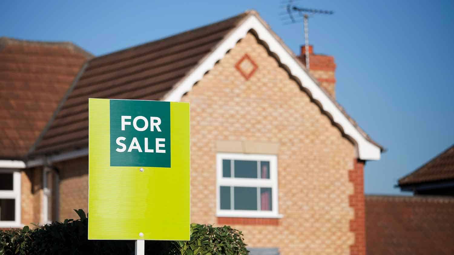 For sale sign outside of a new build house