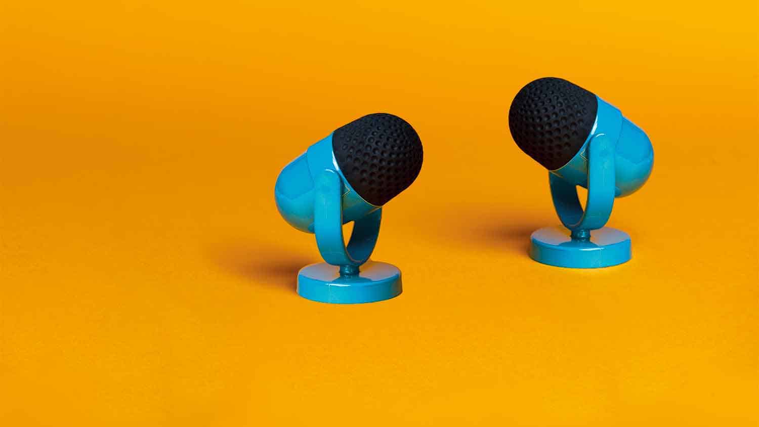 Two blue microphones on an orange background