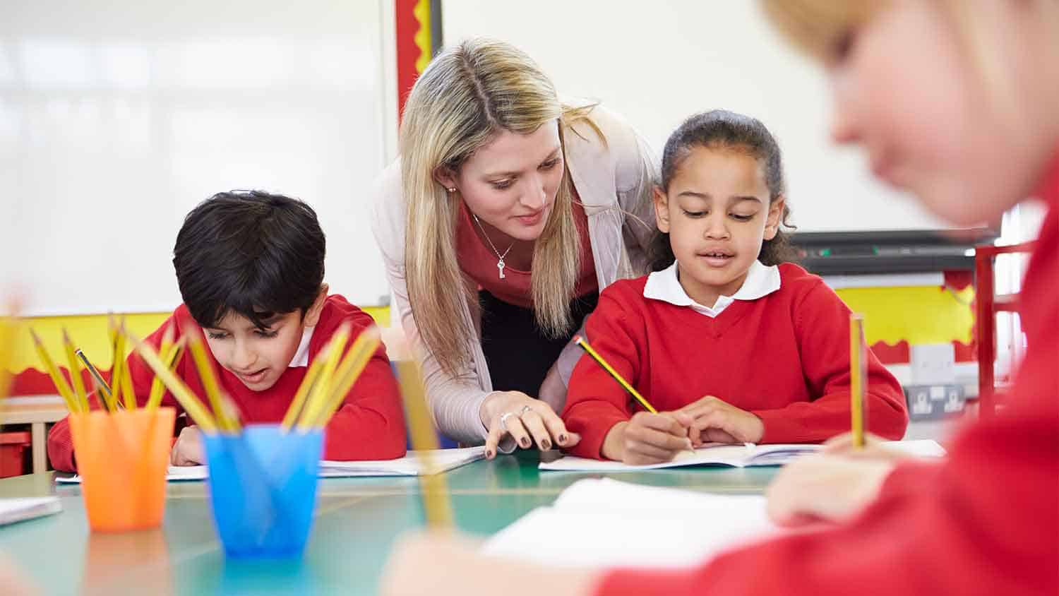 Teacher helping primary school children with their work