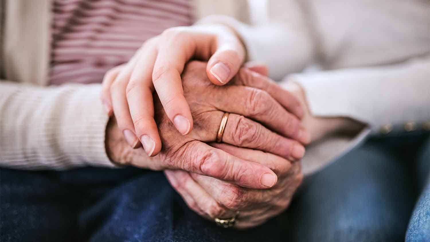 Woman and and older woman holding hands