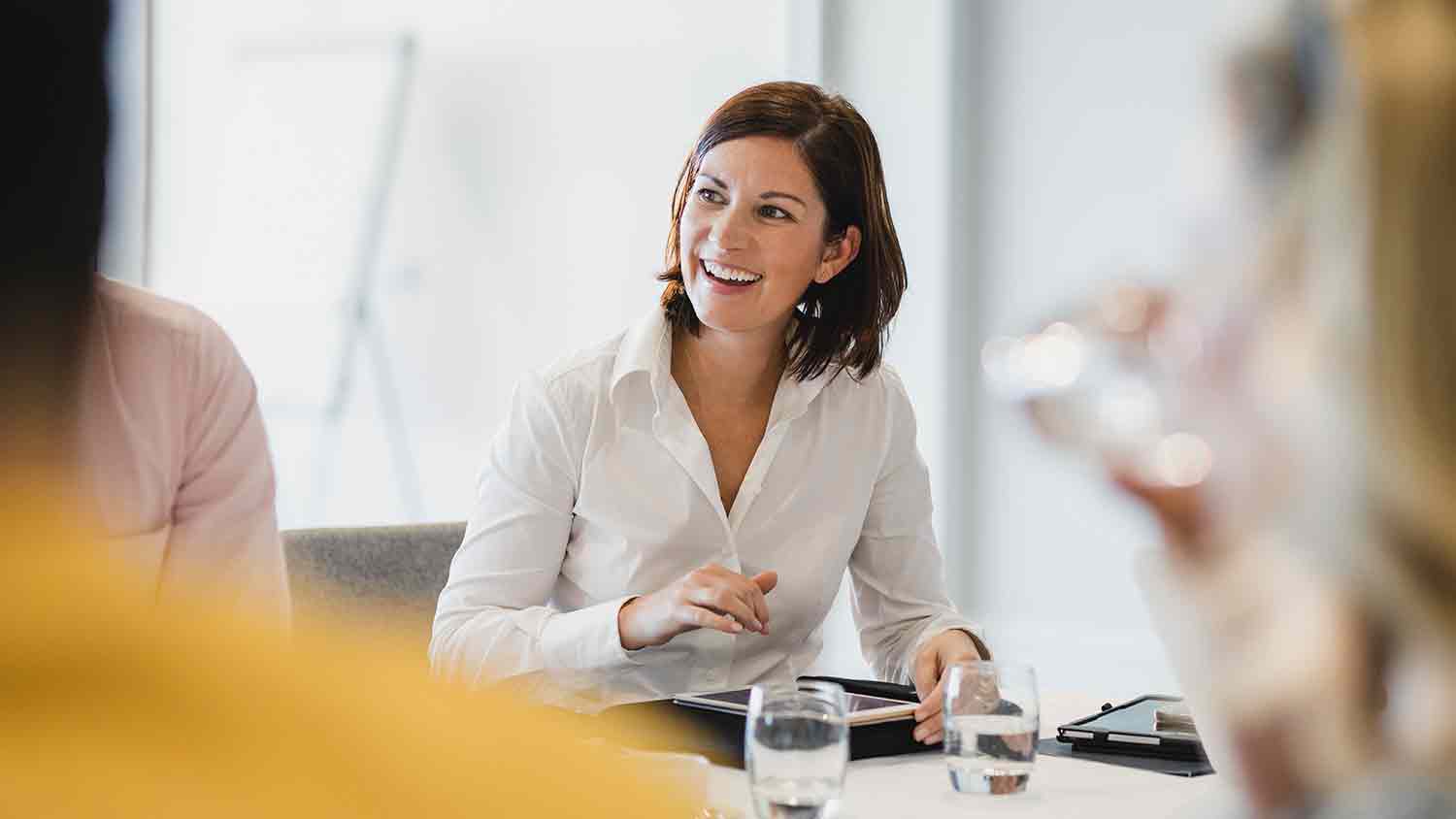 Business woman working on a tablet at a table.