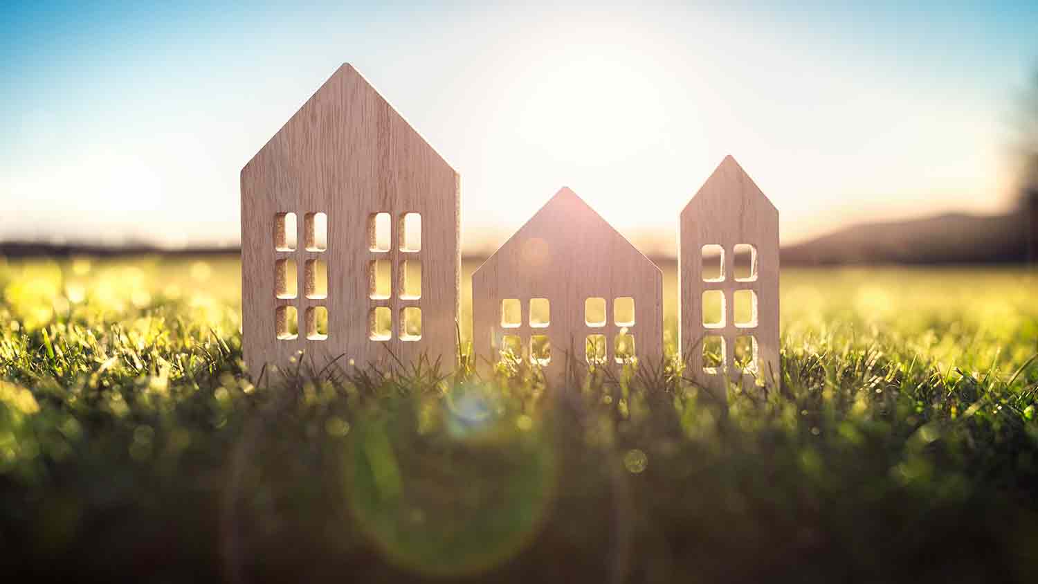 Three small parts of a wooden house lines up, the sun is shining in the background