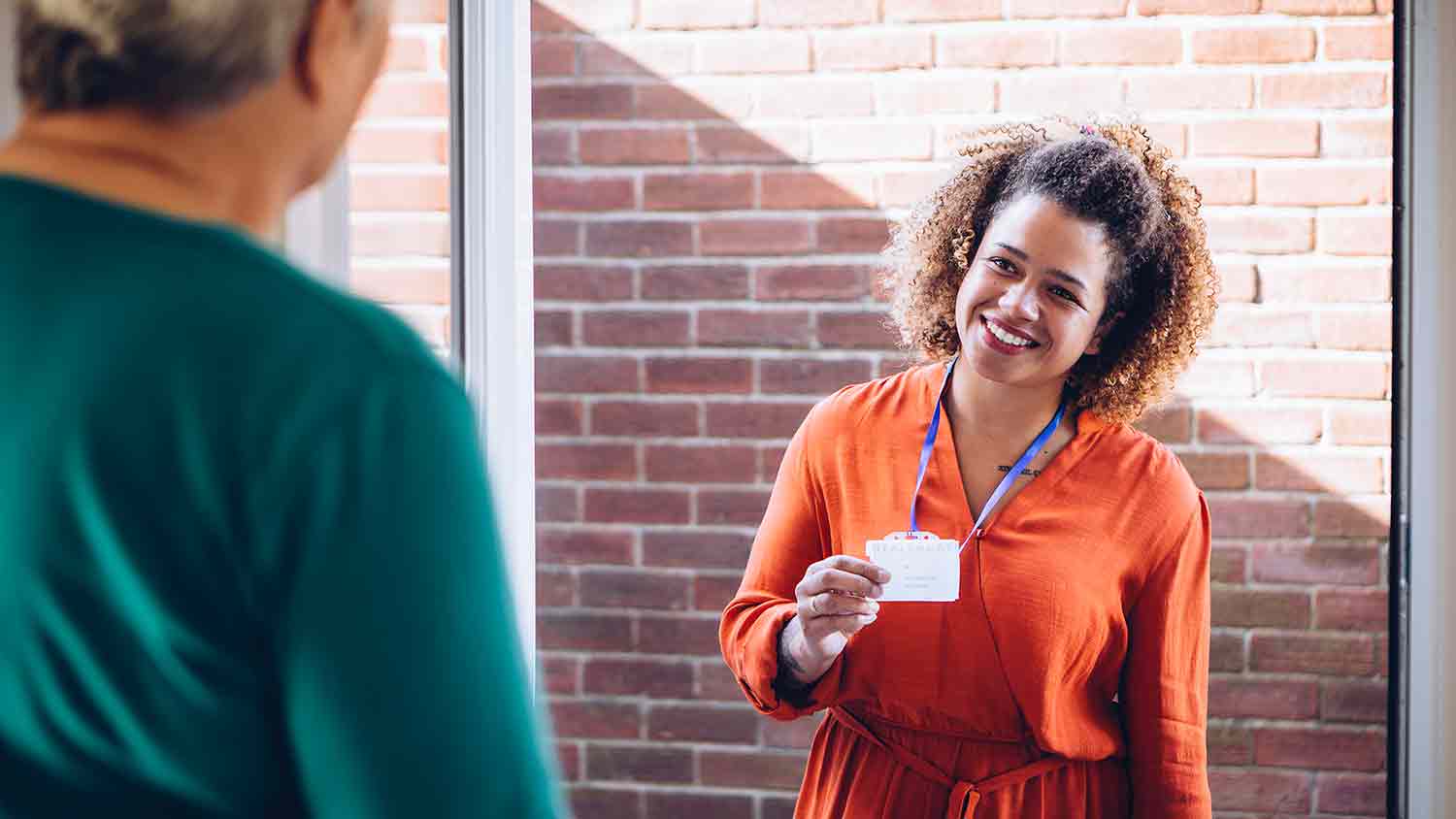 Volunteer knocking on a door and presents her identification