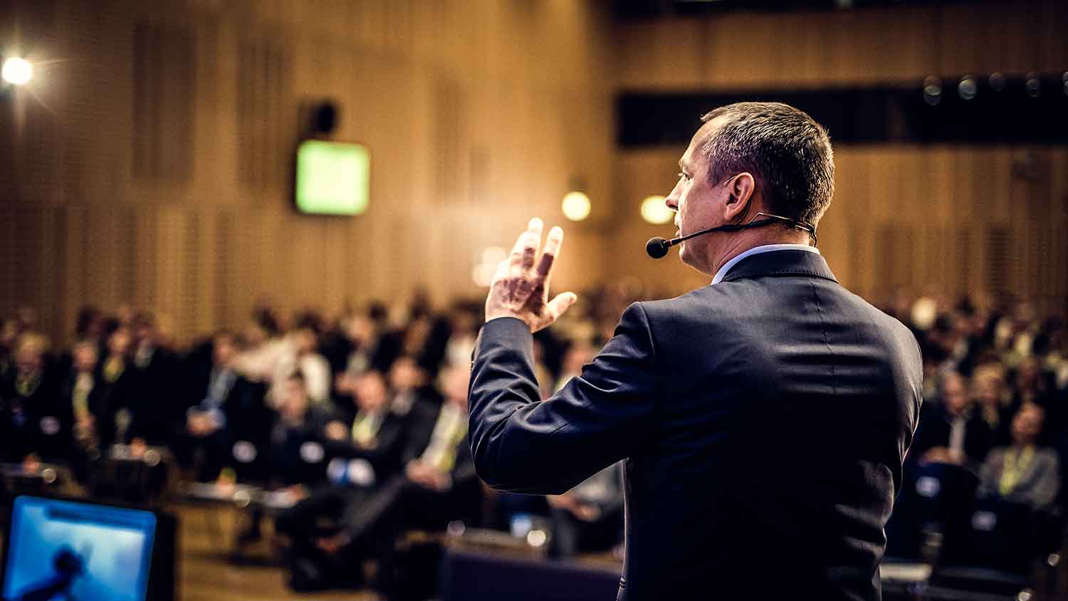 Man addressing a hall of people