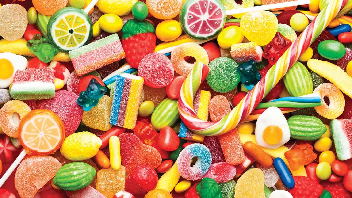 A variety of brightly coloured sugary sweets spread out on a table