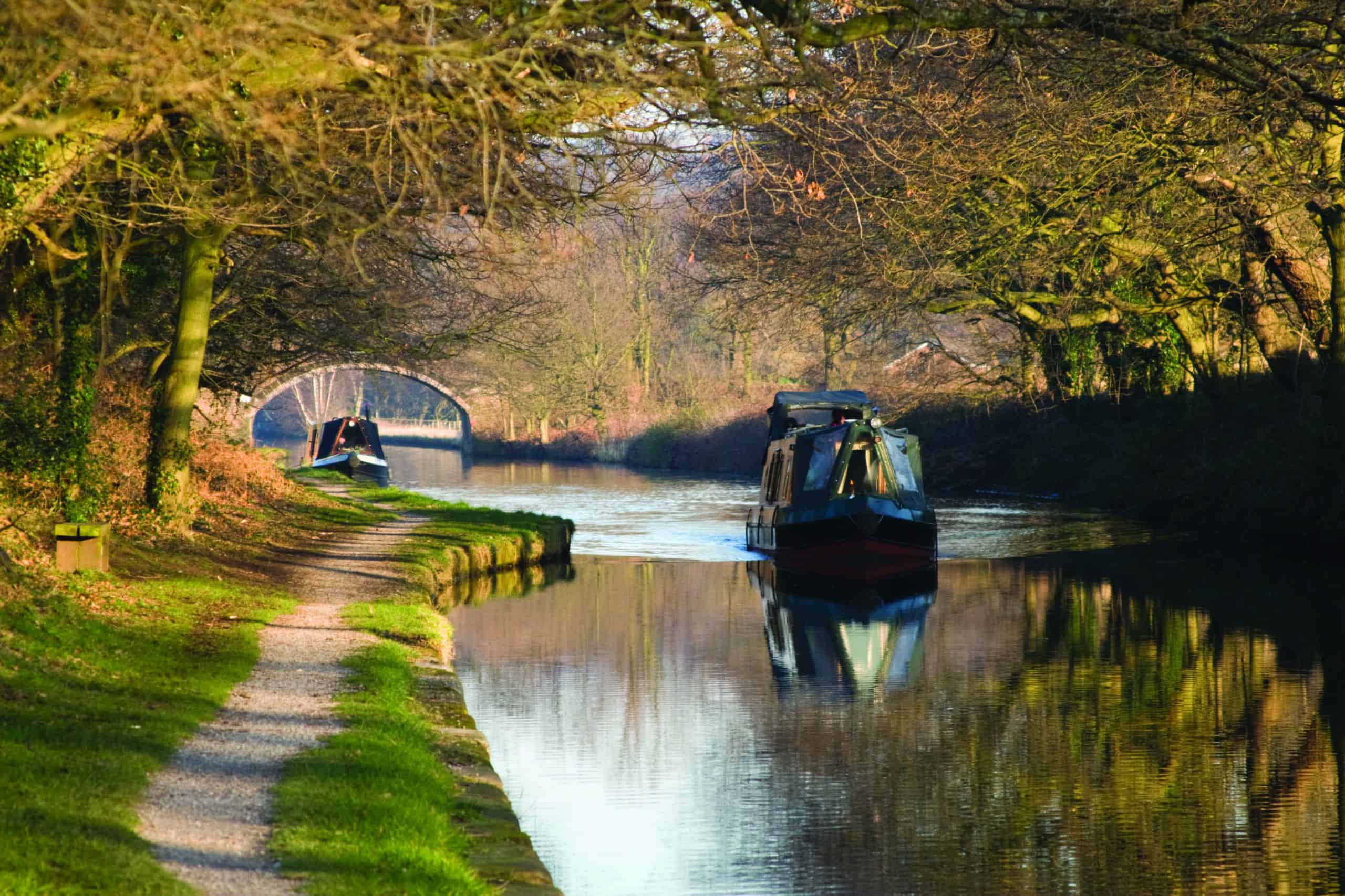 A canal with canal boats floating on it