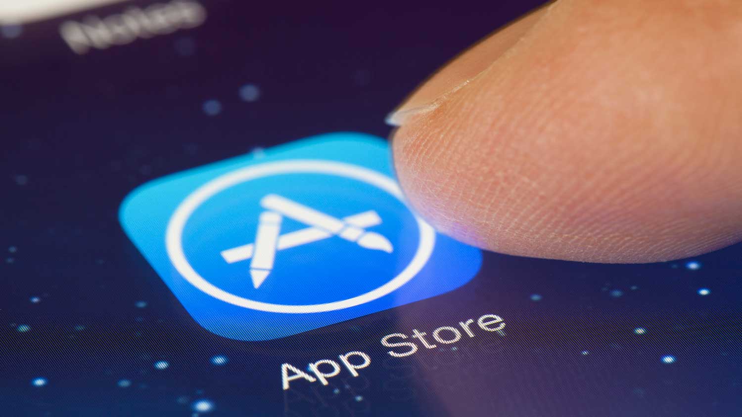 A finger about to select the 'app store' app on a smart device