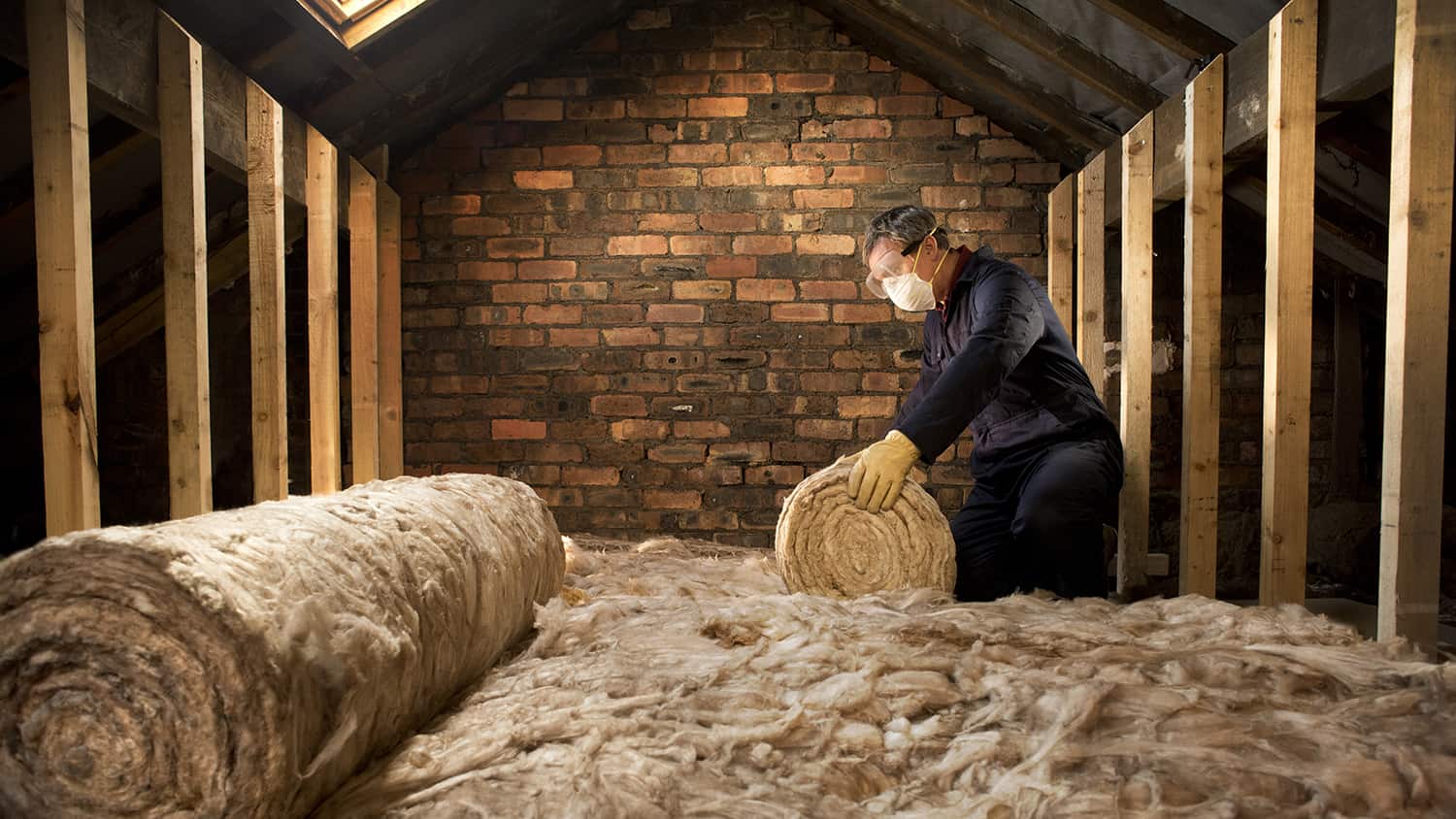 Man puts insulation in a loft