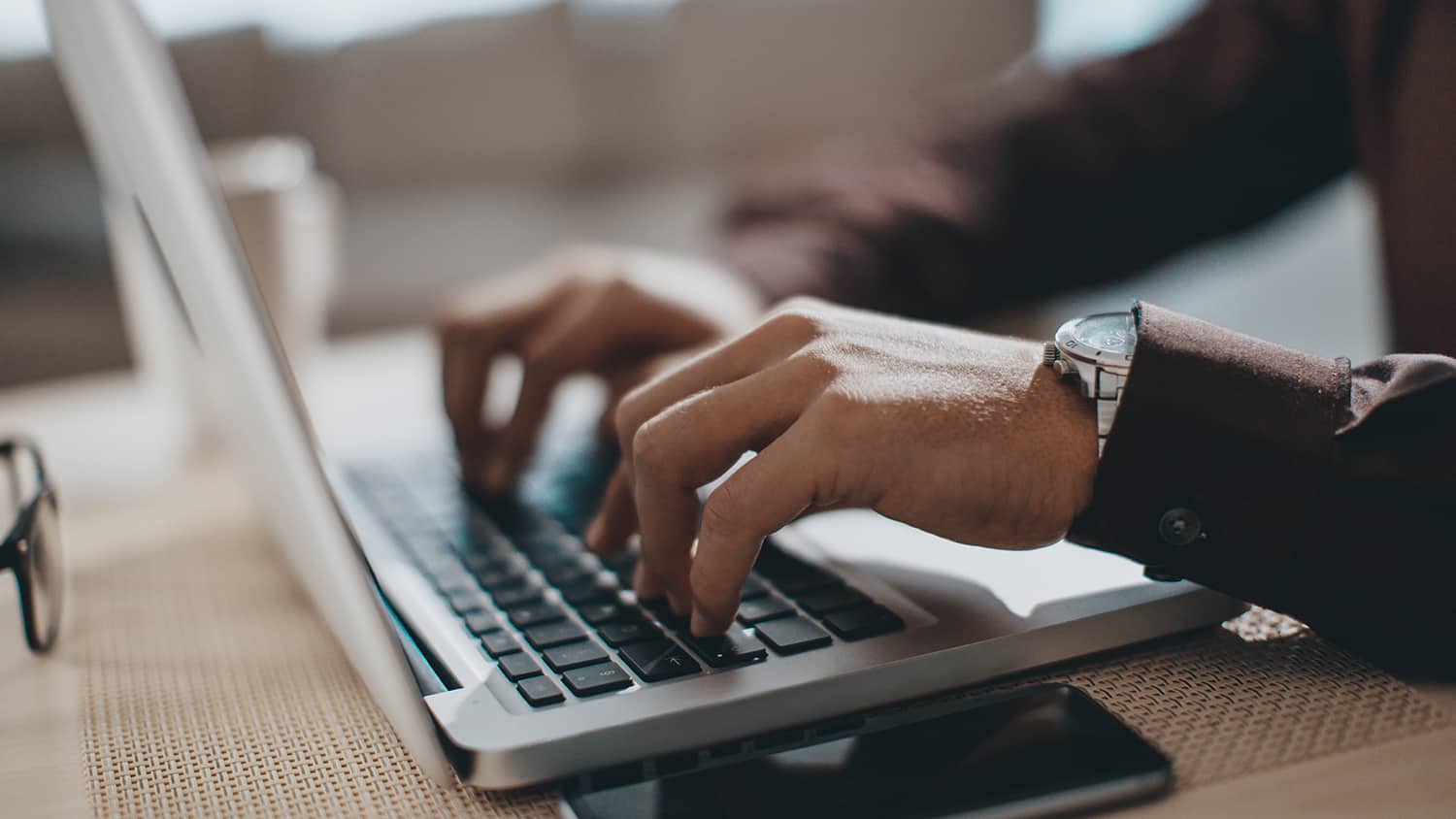 Hands of a man typing on a laptop computer