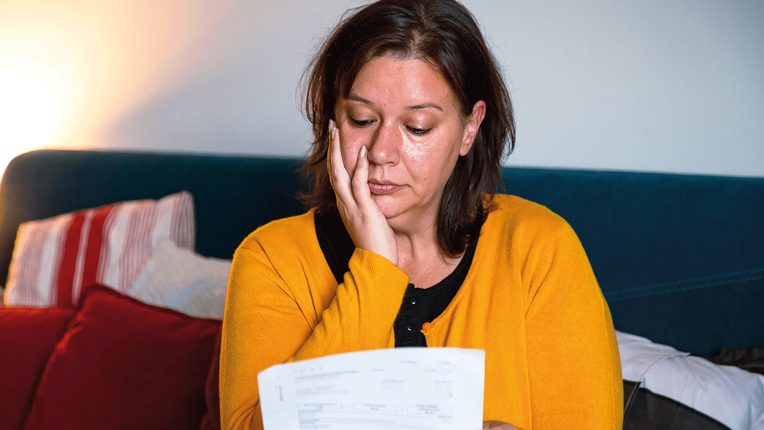 A woman looking worried at a bill to pay