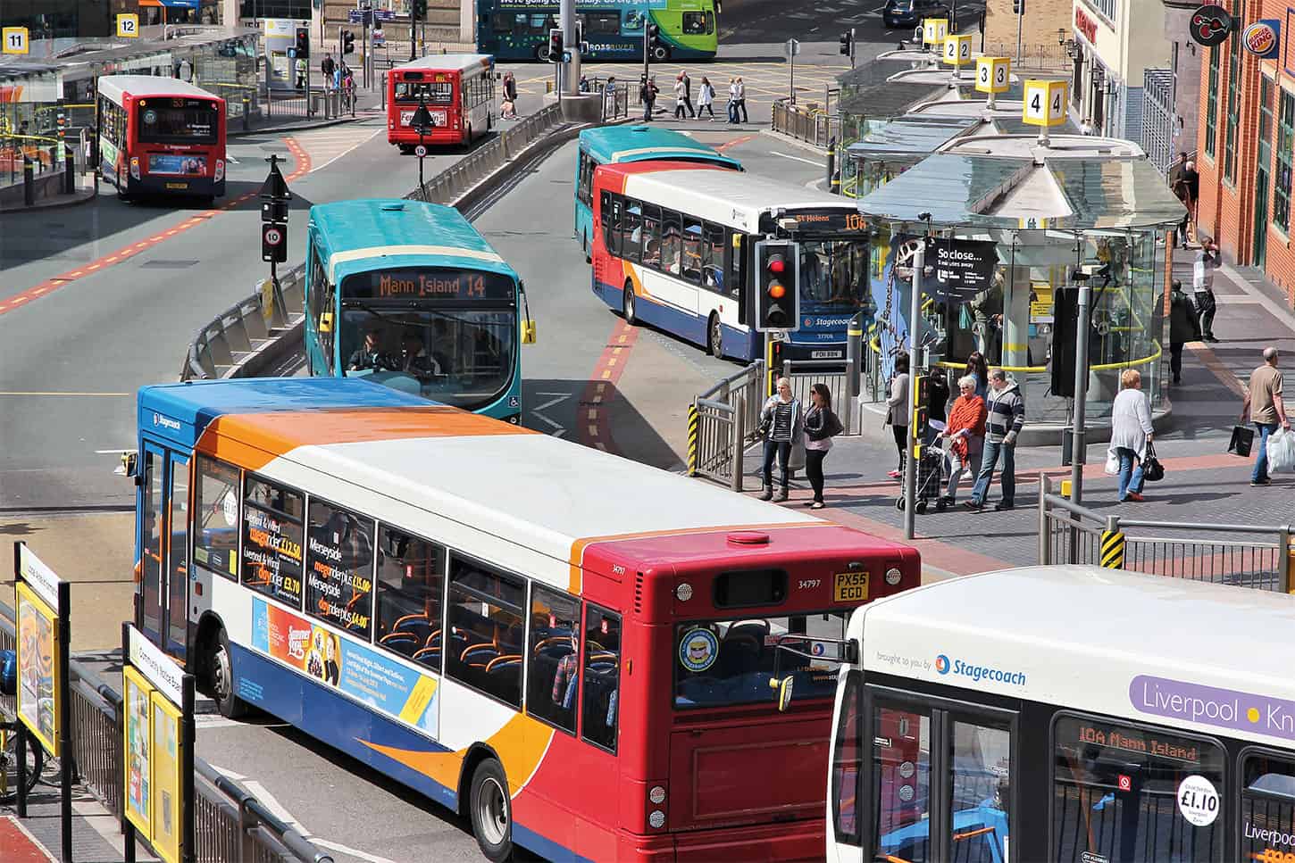 A number of local buses waiting at a red light