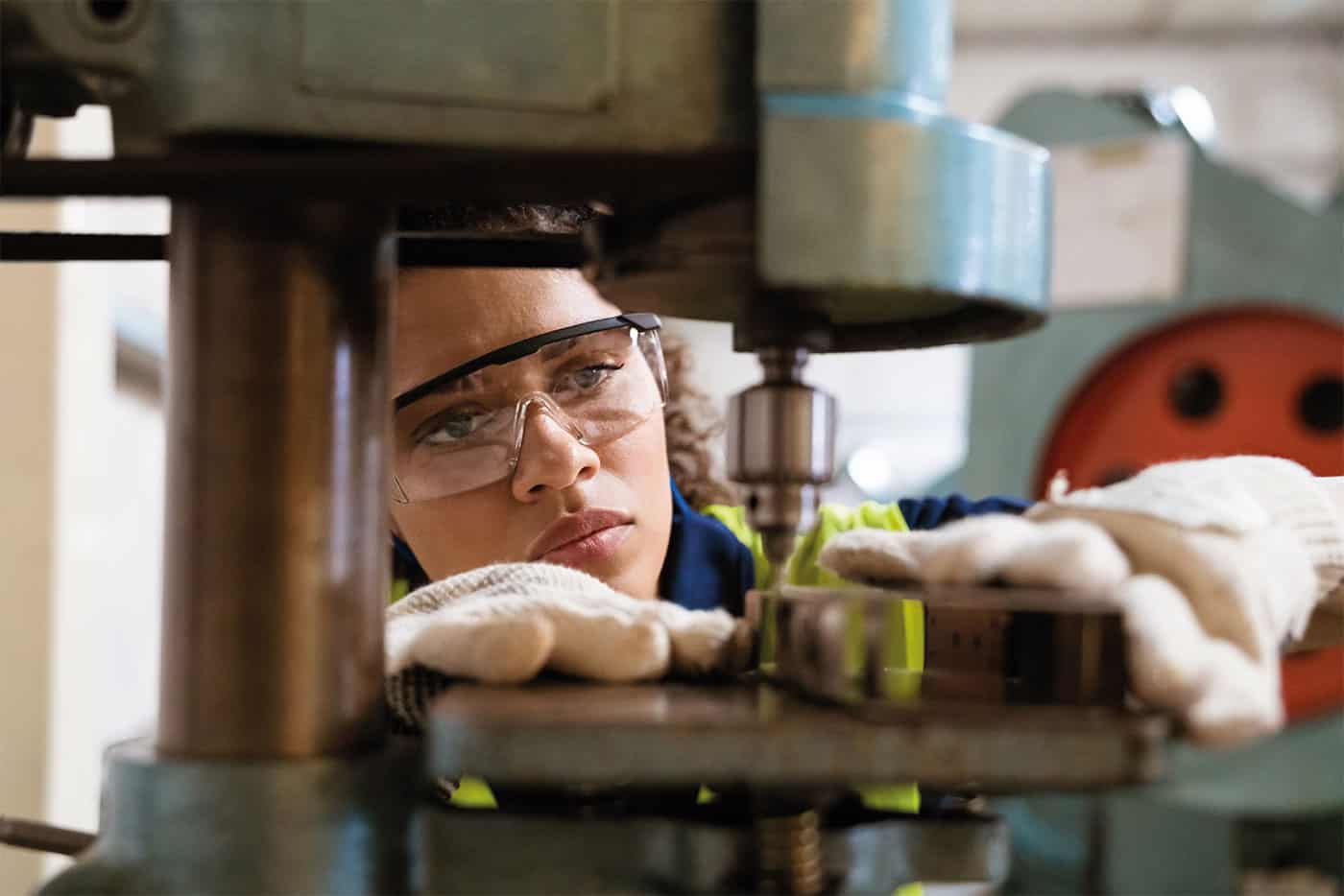 Young woman working with a drilling machine