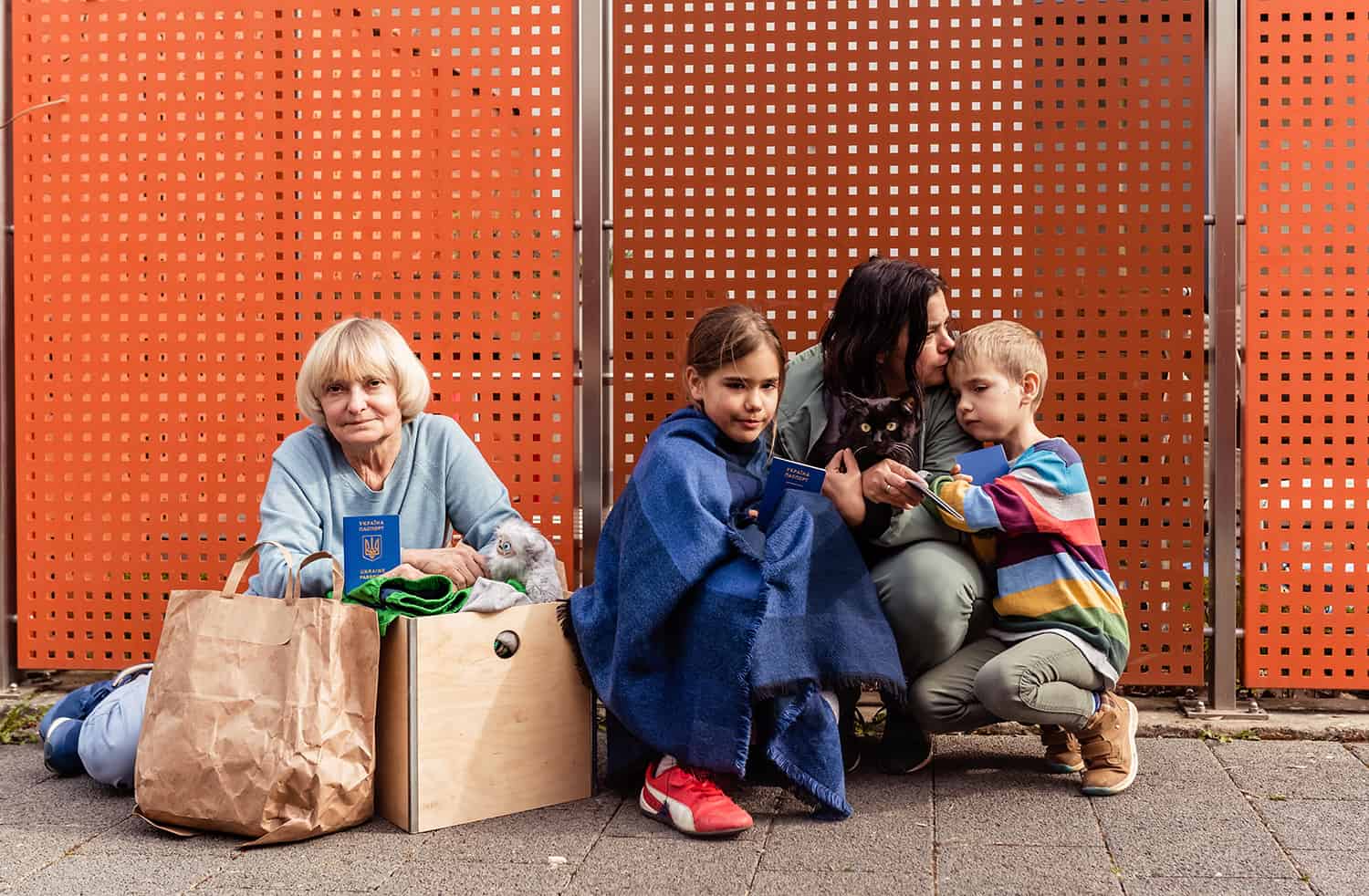 Family of Ukrainian refugees with children and pet cat holding passports.