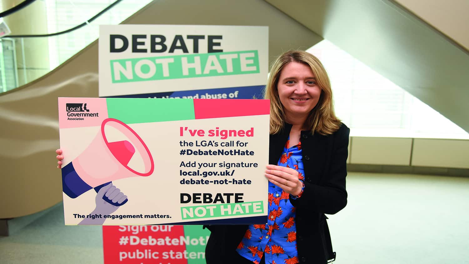 Cllr Gould holding a Debate not Hate sign at conference