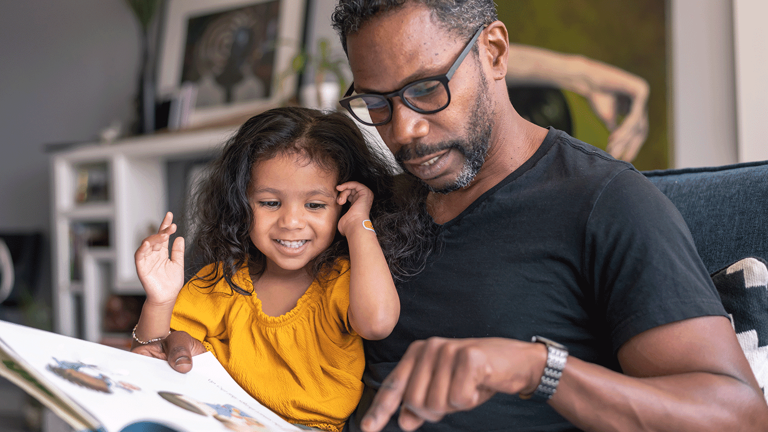 father showing a book to his young daughter