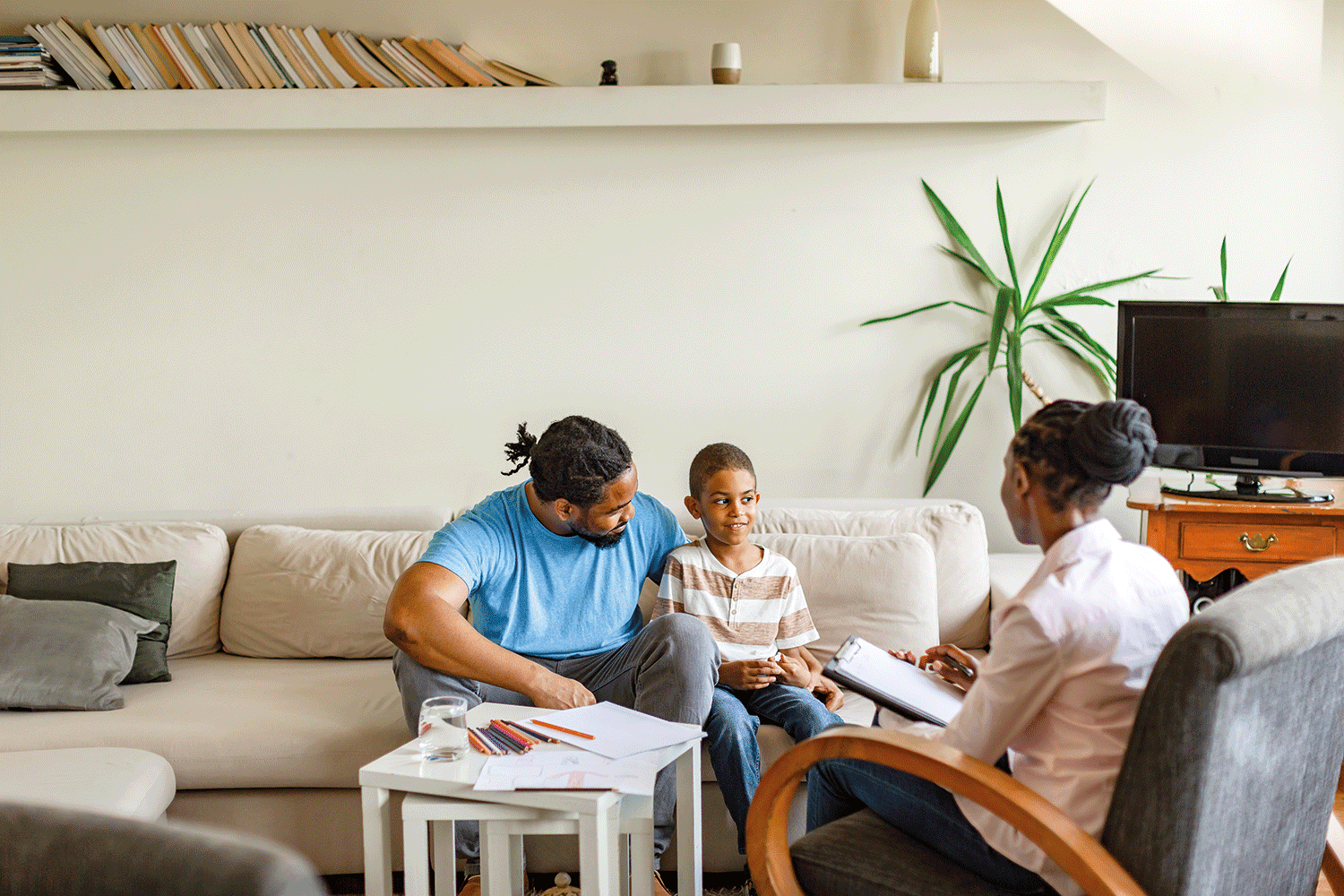 a child in a session with its dad a and a counsellor