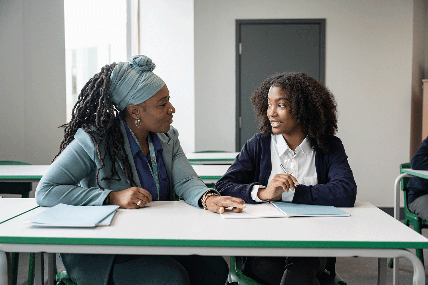 teacher talking to a student in the classroom