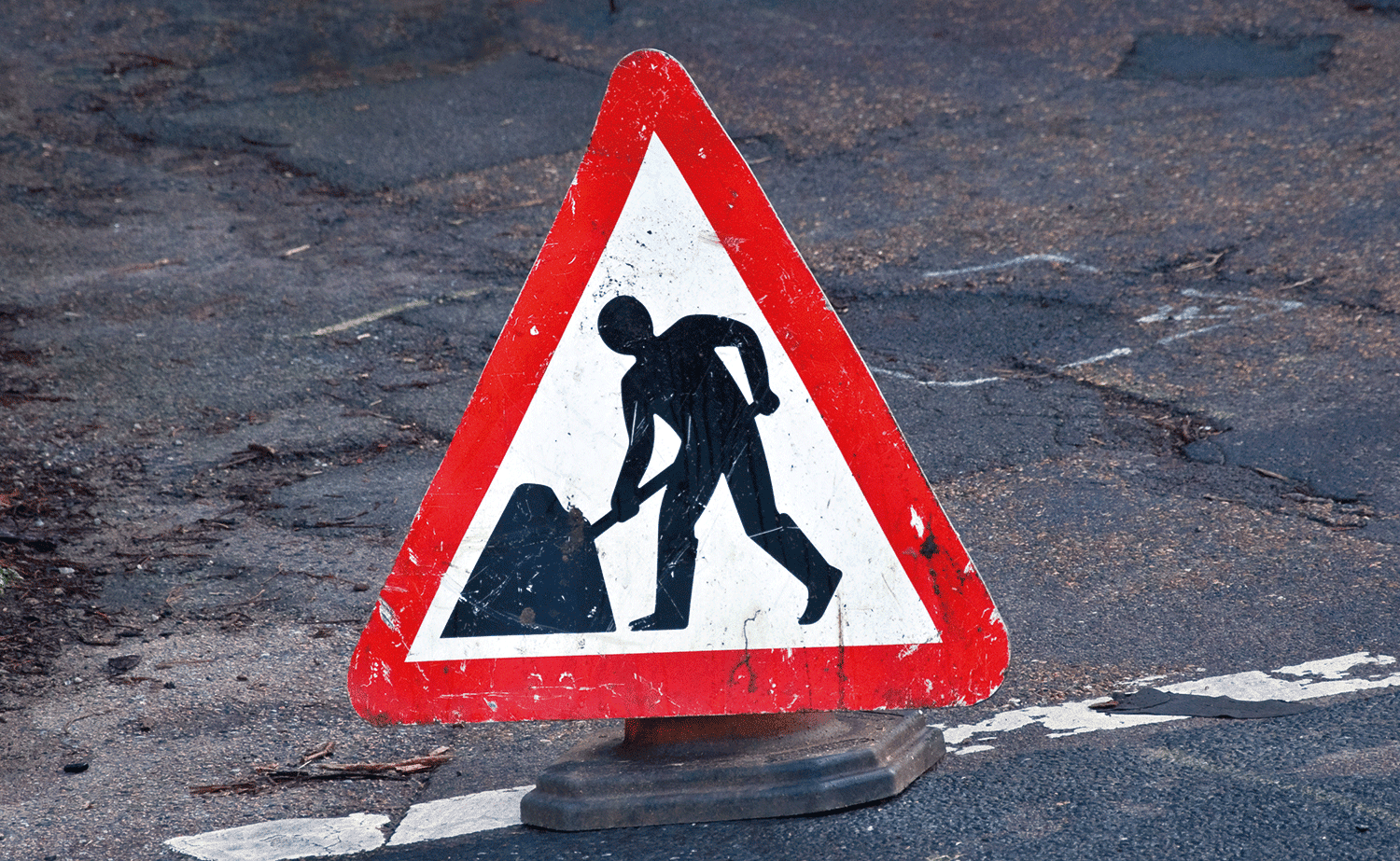 triangular sign that shows work on the road