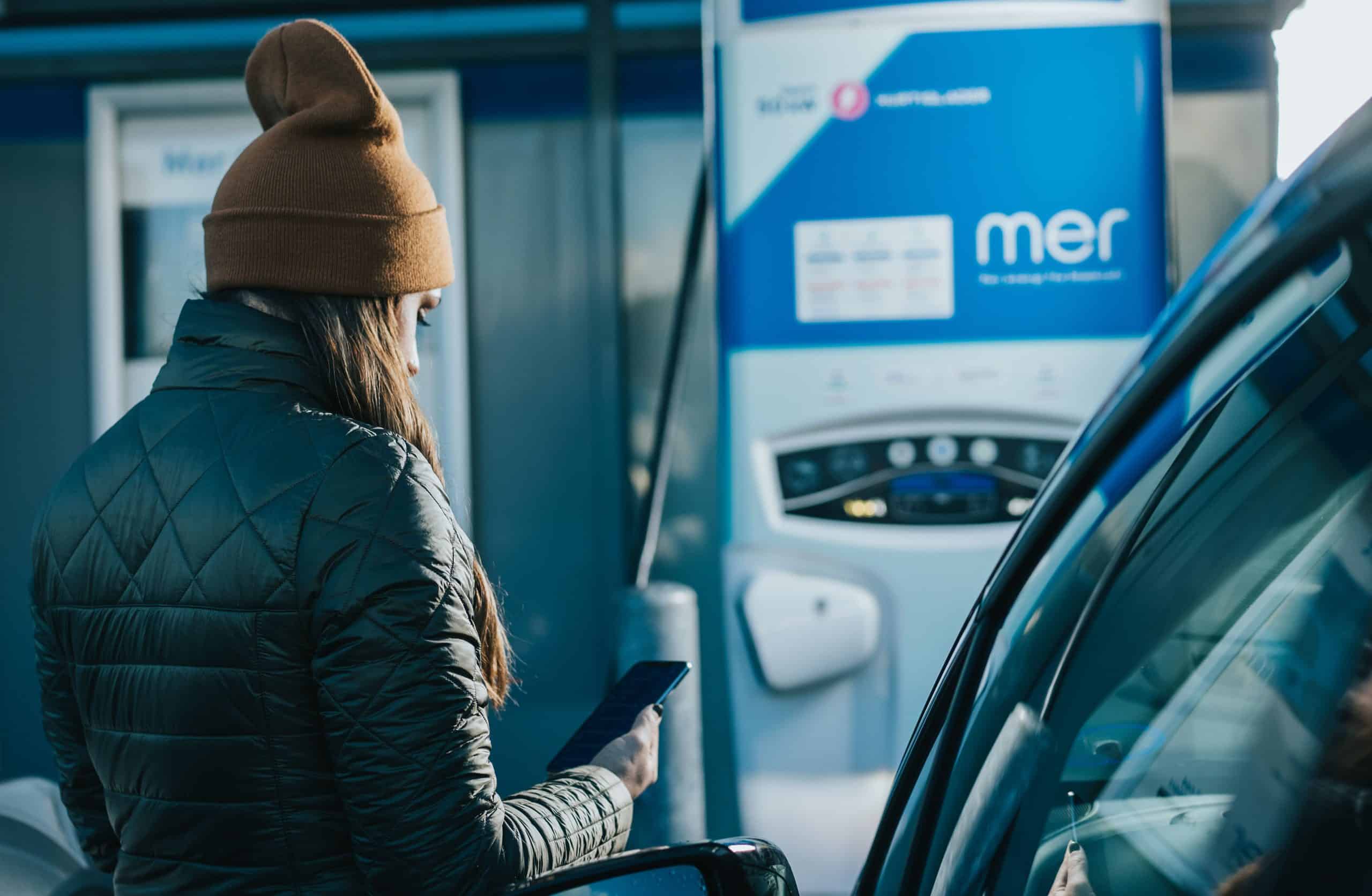 woman charging electric vehicle at Mer charging point