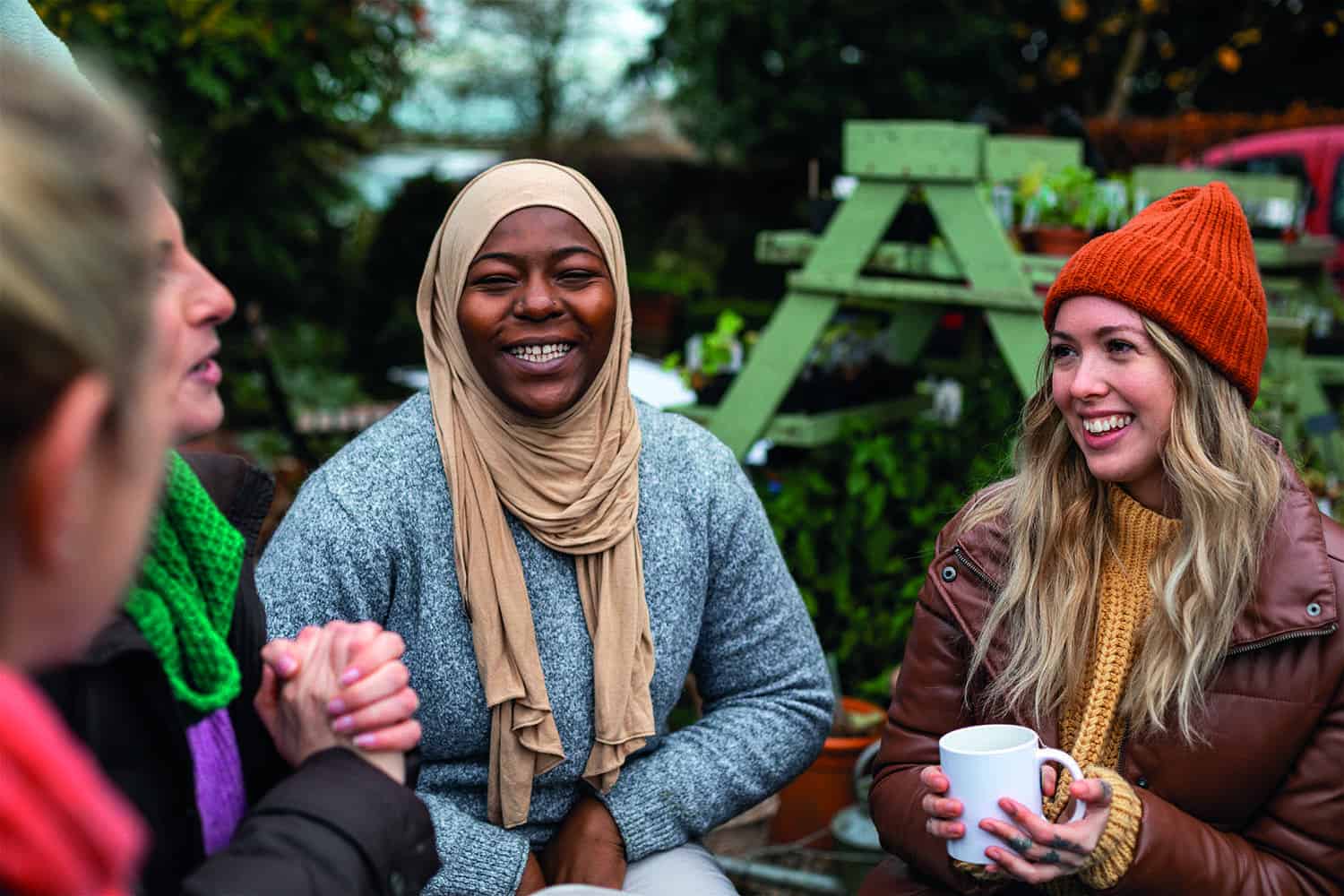 A group of women from different backgrounds stood in a circle chatting