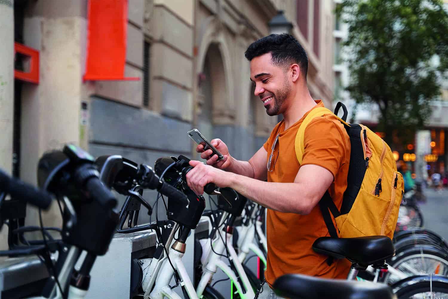 A man using its mobile phone near many bycicles
