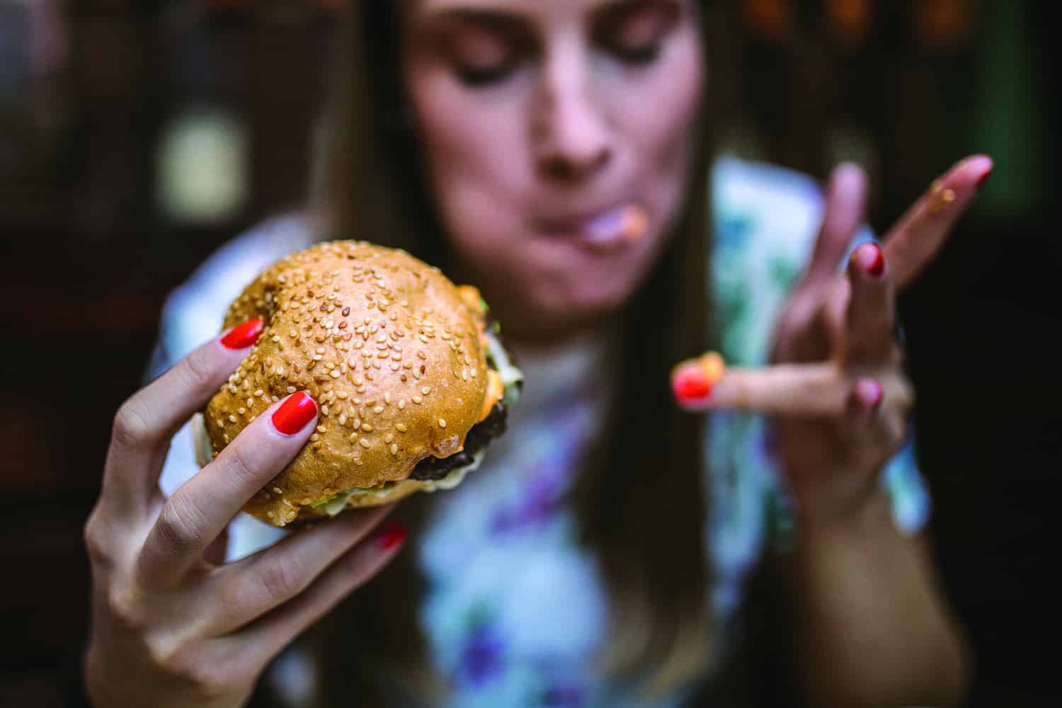 : young woman eating messy burger