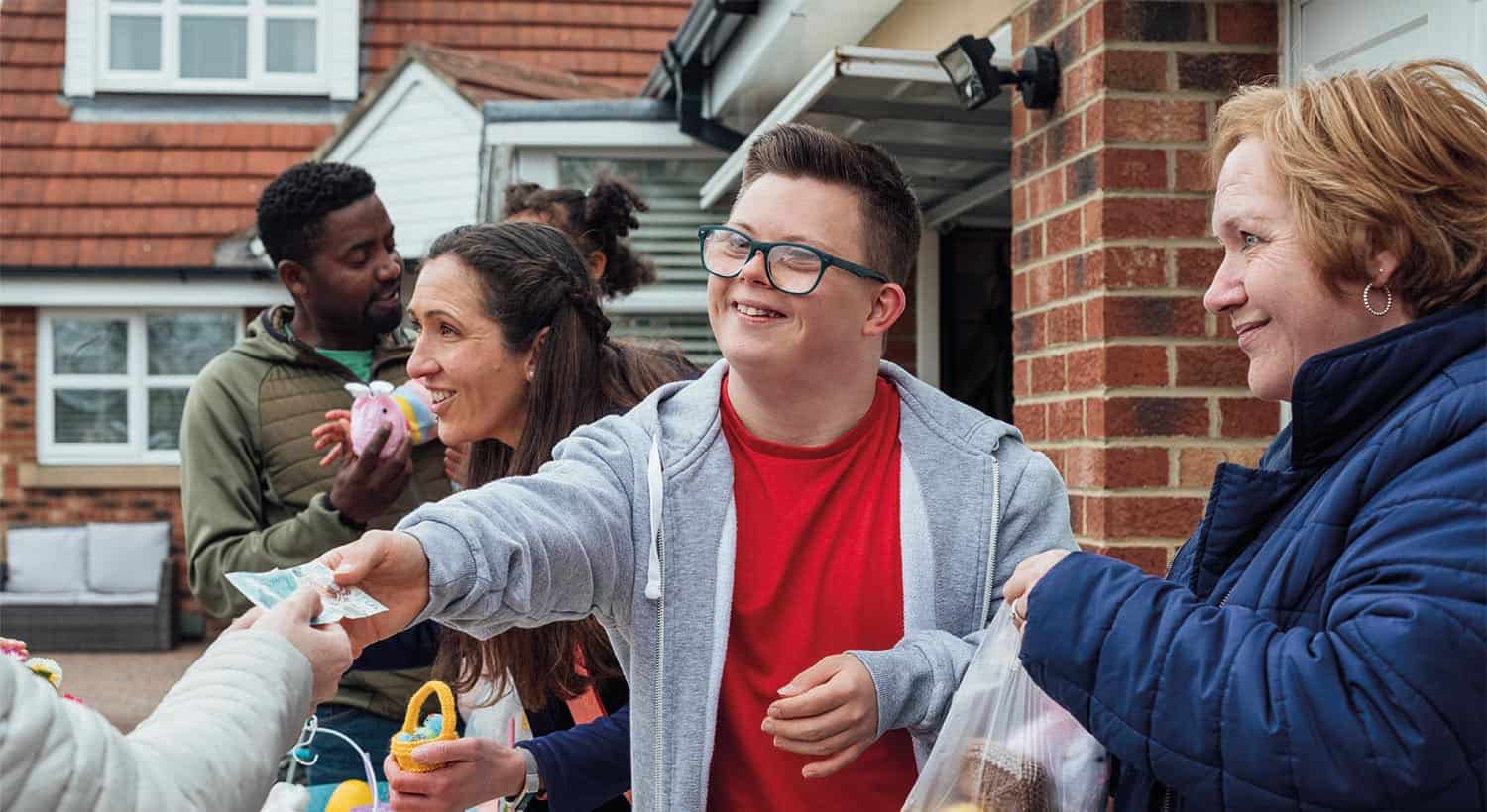 Adolescent male with Down’s Syndrome giving change on crafts stall