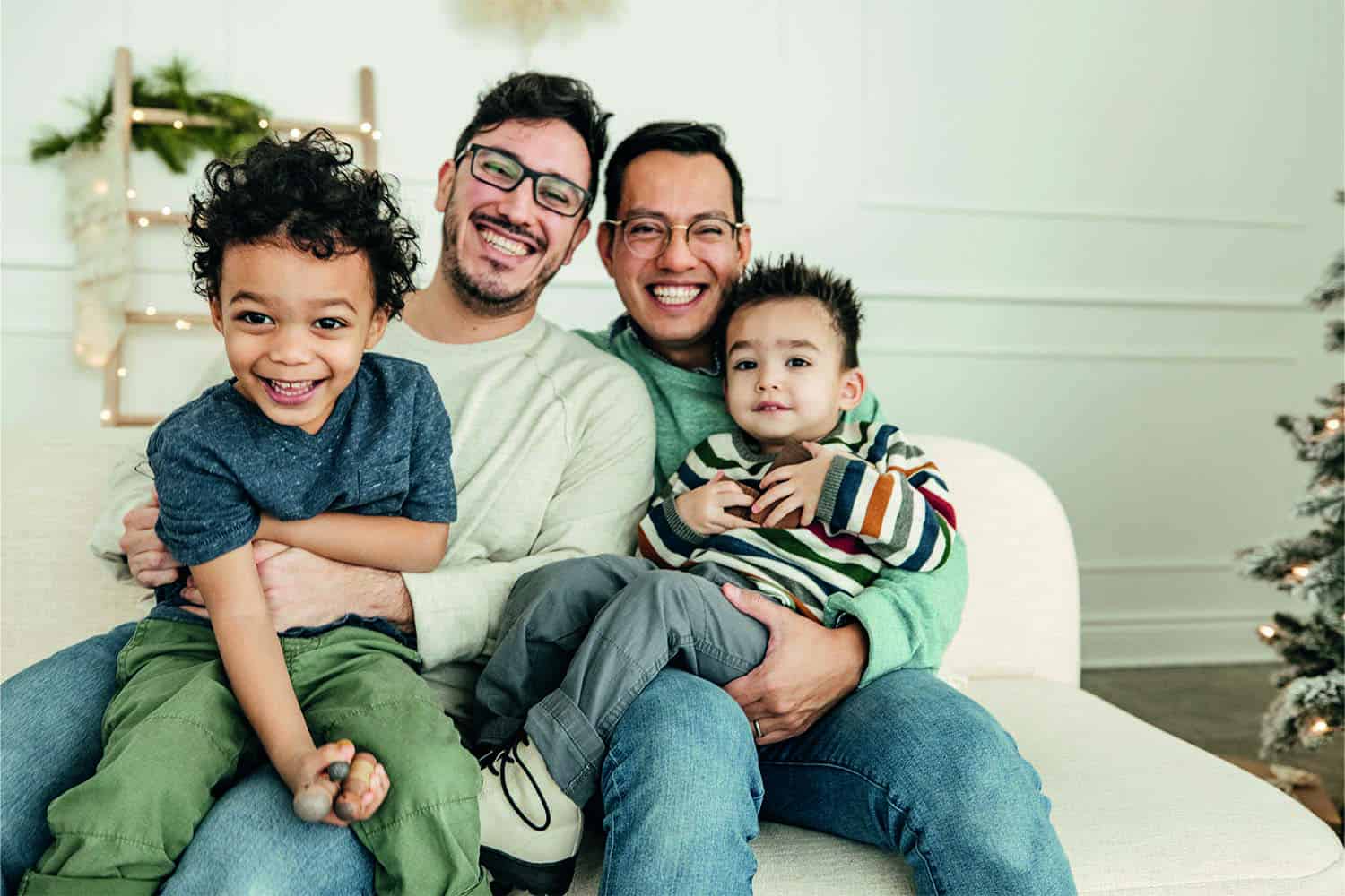 Smiling male couple with their two adoptive children