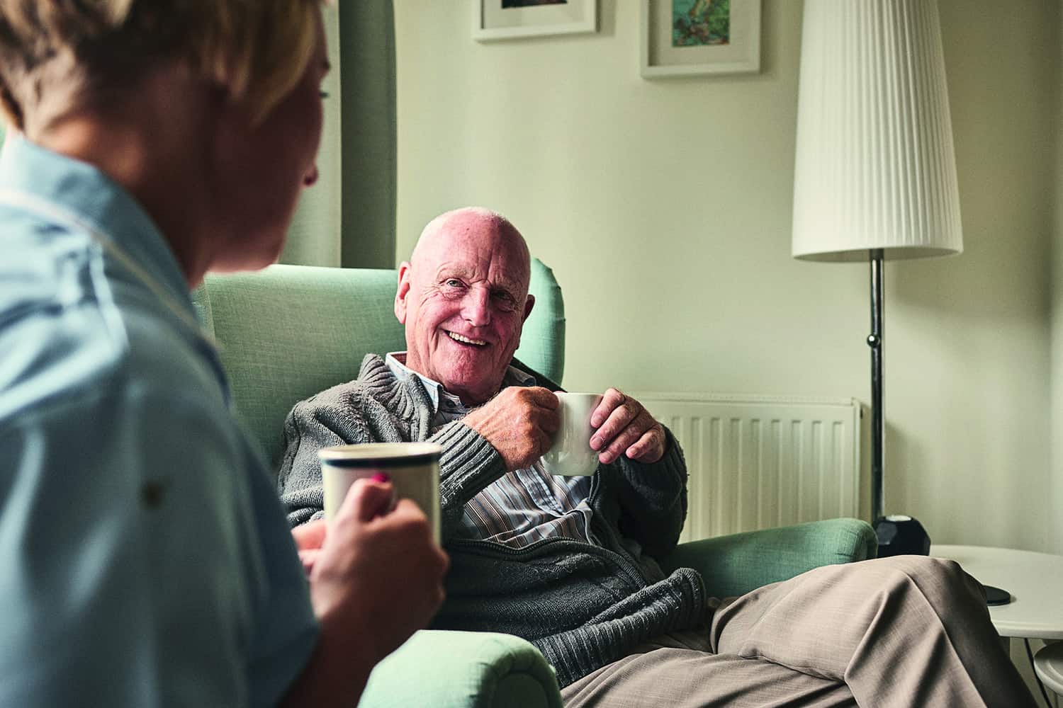 Two elderly people drinking tea together