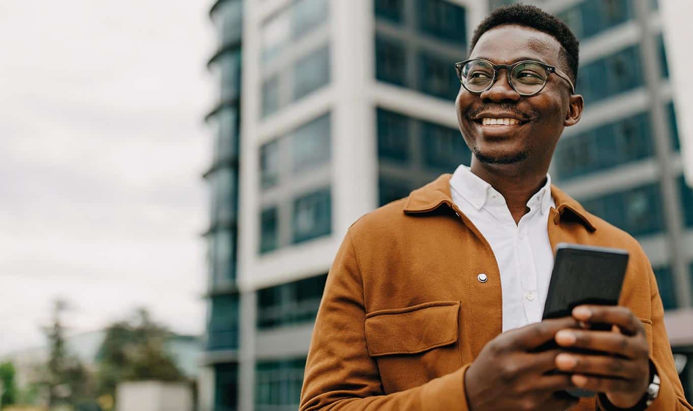 young man smiling using his mobile phone