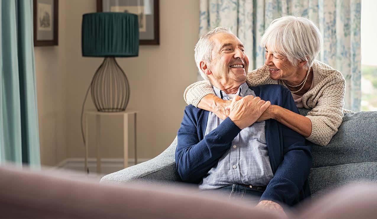 older couple hugging on sofa