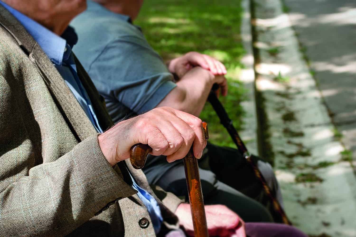 Close-up of older people’s hands on walking sticks