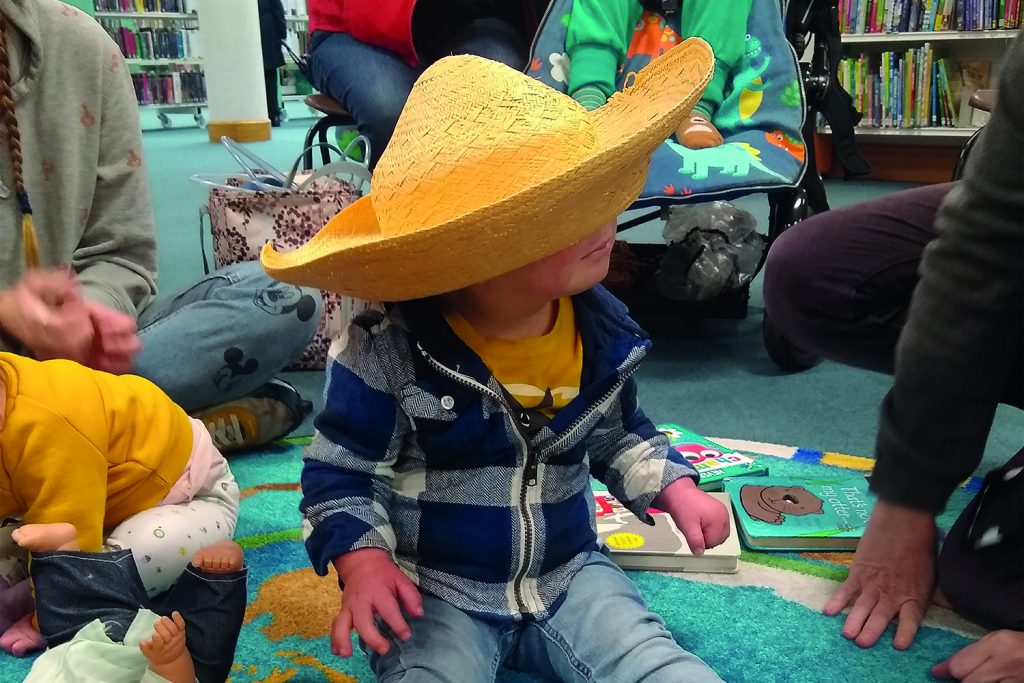 Pix of pre-school children playing and reading books in library